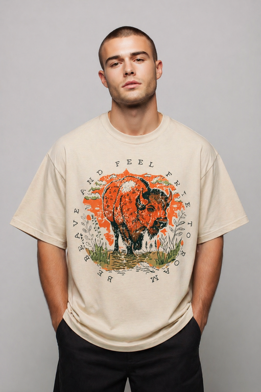 Man wearing a beige t-shirt with a graphic design of a bison on a gray background