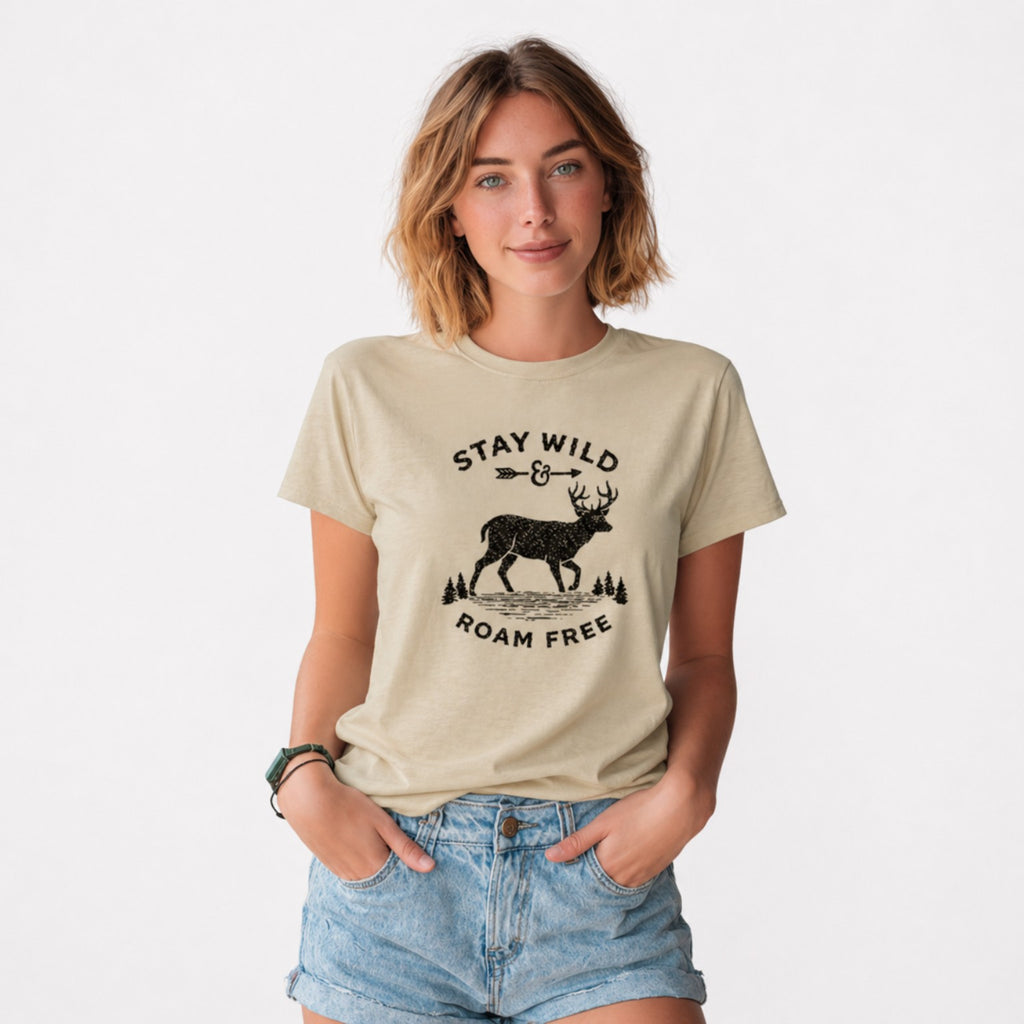 Woman wearing a beige Stay Wild Roam Free graphic t-shirt featuring adventure-inspired artwork celebrating freedom, exploration, and outdoor living.