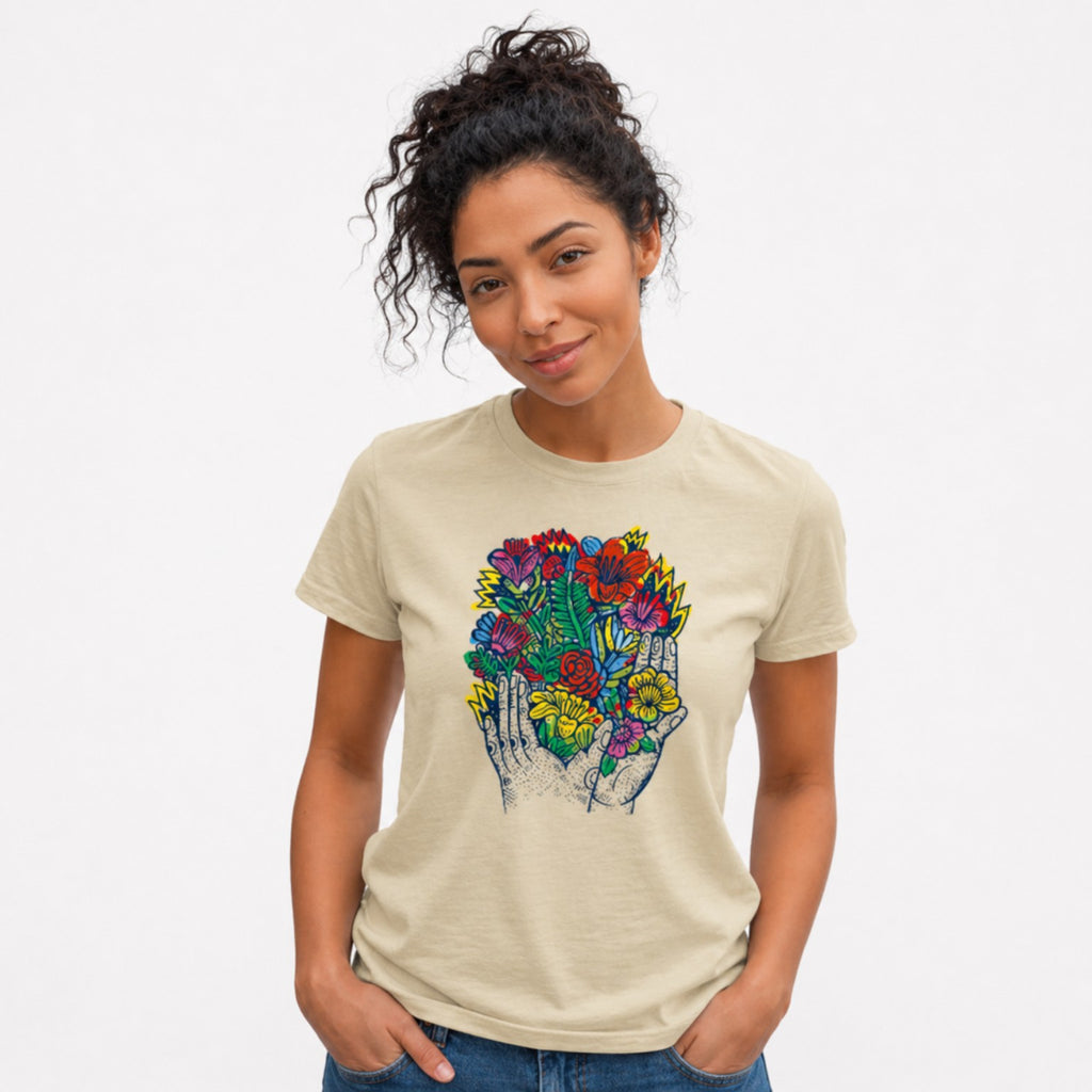 Woman wearing a beigeBloom in Hand graphic t-shirt featuring floral hand artwork inspired by nature, creativity, and botanical illustration.
