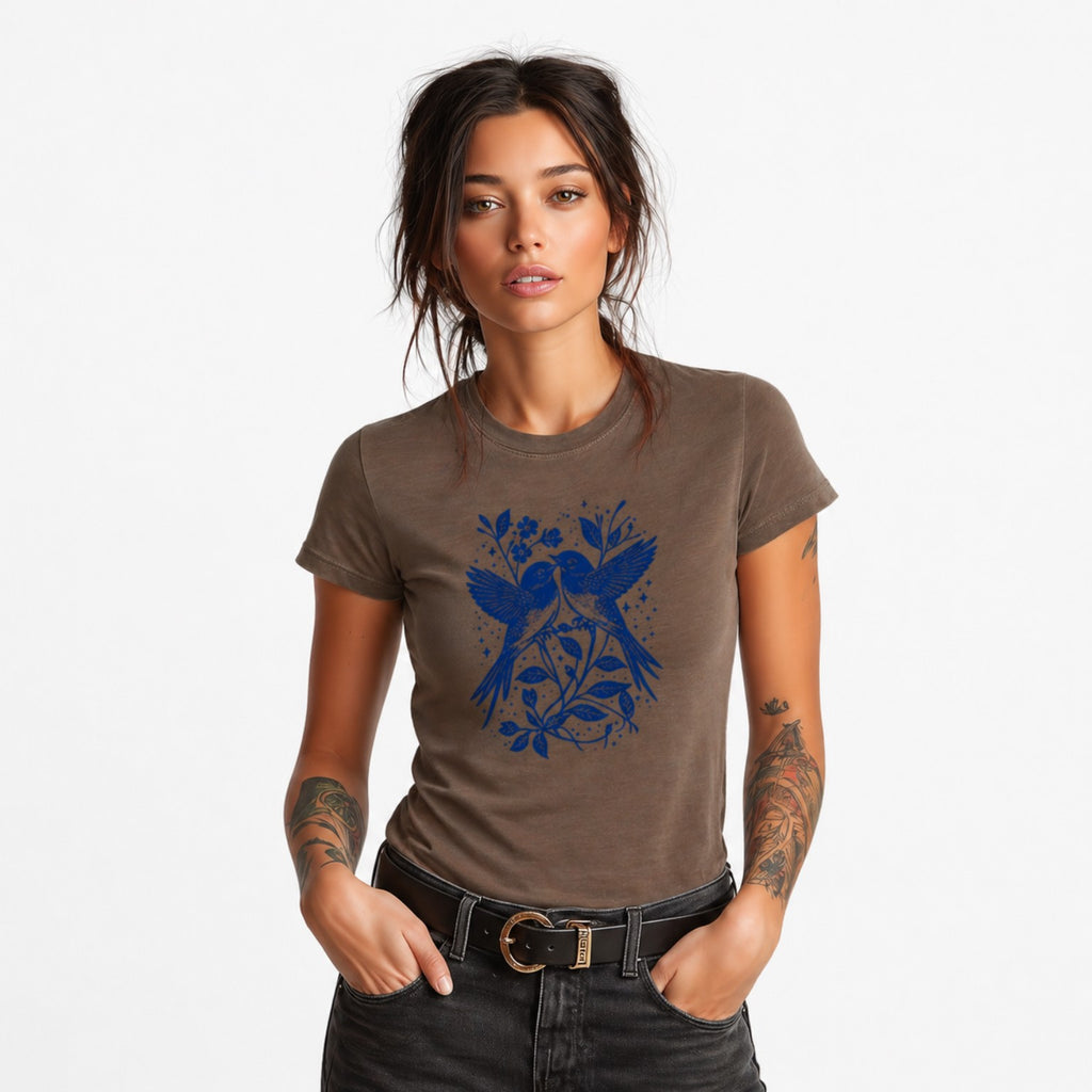 Woman wearing a brown Bluebird Garden Folk graphic t-shirt featuring bird and floral artwork inspired by folk art and botanical beauty.