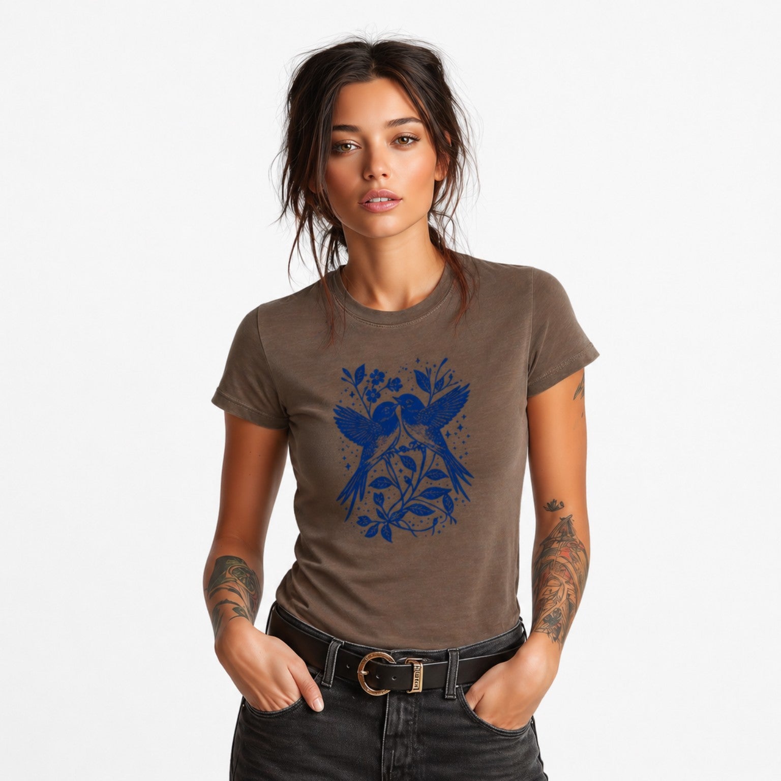 Woman wearing a brown Bluebird Garden Folk graphic t-shirt featuring bird and floral artwork inspired by folk art and botanical beauty.