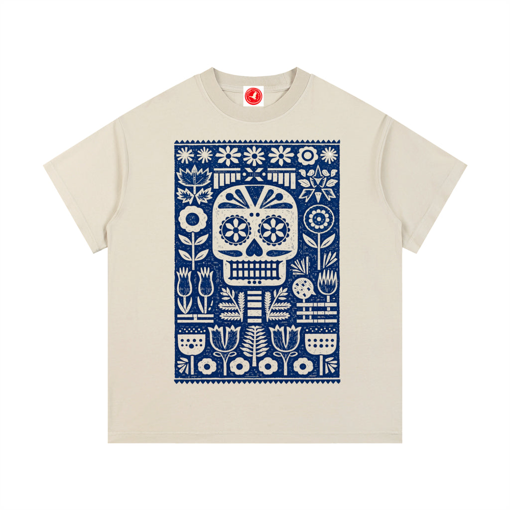 Beige Folk Skull graphic t-shirt featuring decorative skull artwork inspired by folk art and vintage illustration.