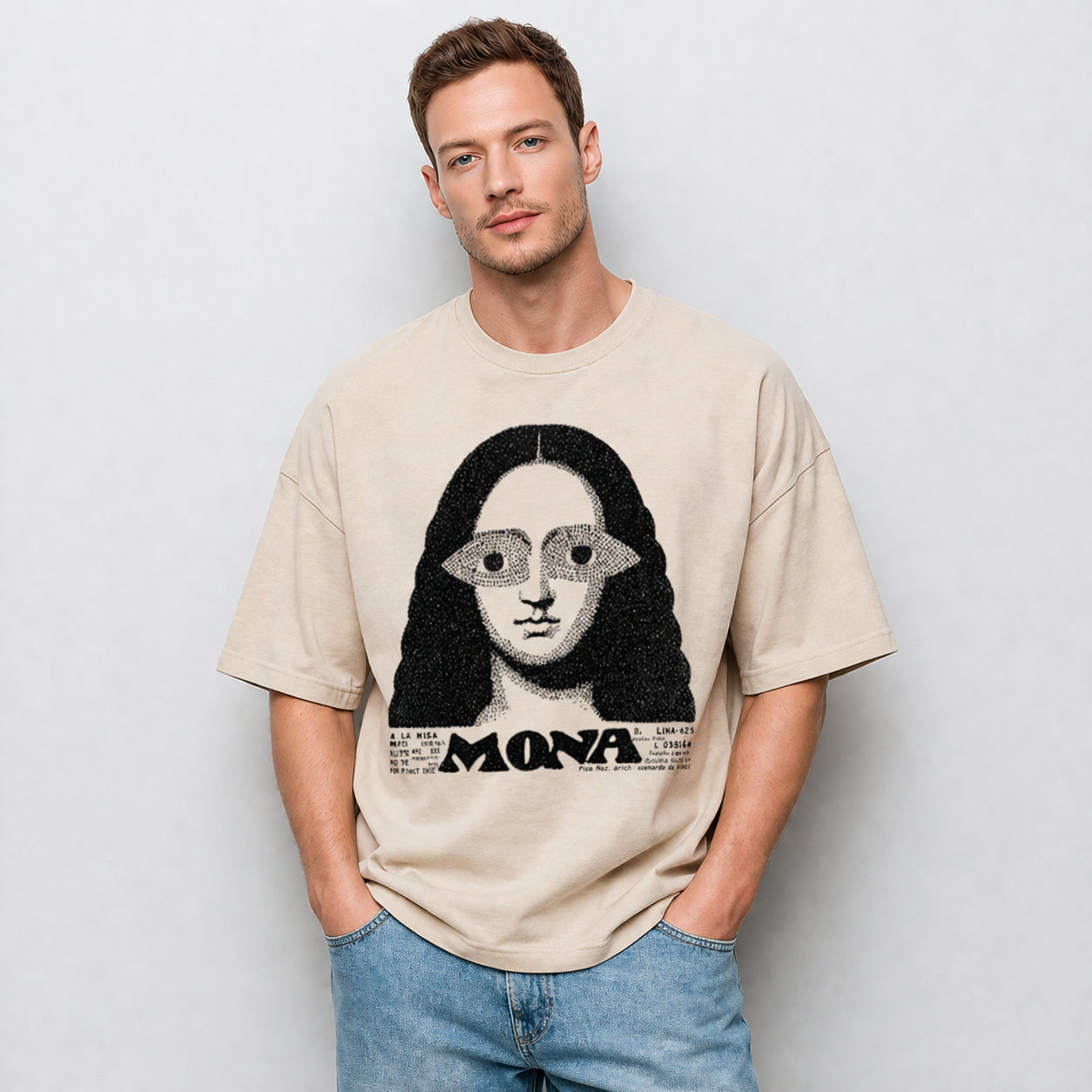 Man wearing a beige Mona graphic t-shirt featuring artistic portrait-inspired artwork with a modern vintage aesthetic.
