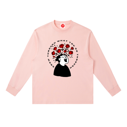 Pink long-sleeve shirt with graphic design and text on a white background
