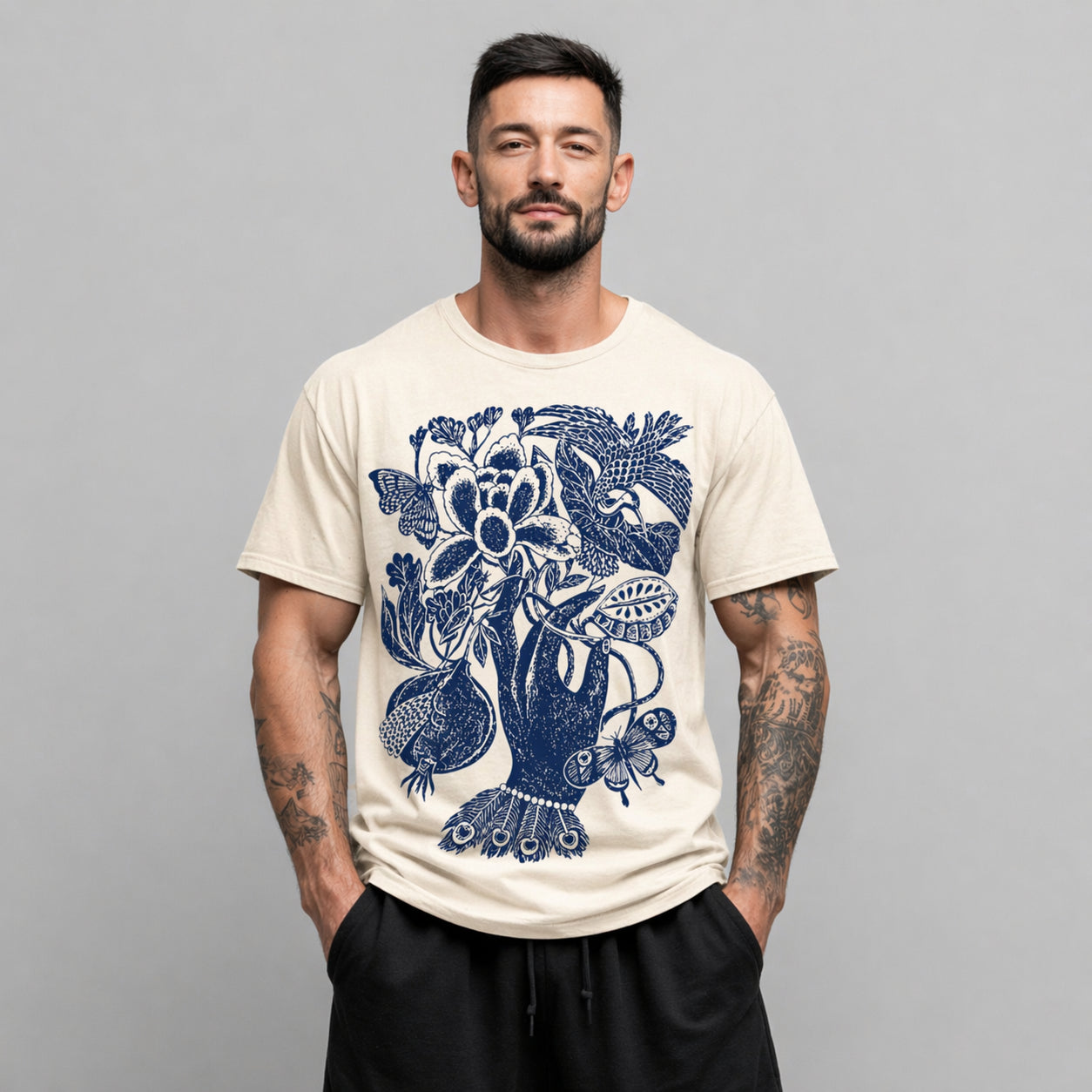 Man wearing a beige Botanical Hand graphic t-shirt featuring botanical hand artwork inspired by vintage floral illustration
