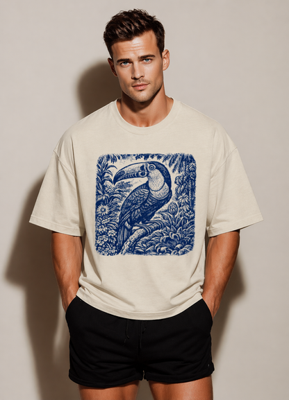 Man wearing a beige t-shirt with a blue peacock design against a plain background