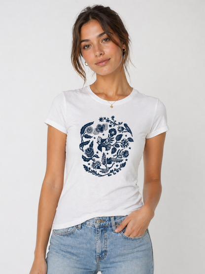 Woman wearing a white t-shirt with a blue floral design on a plain background