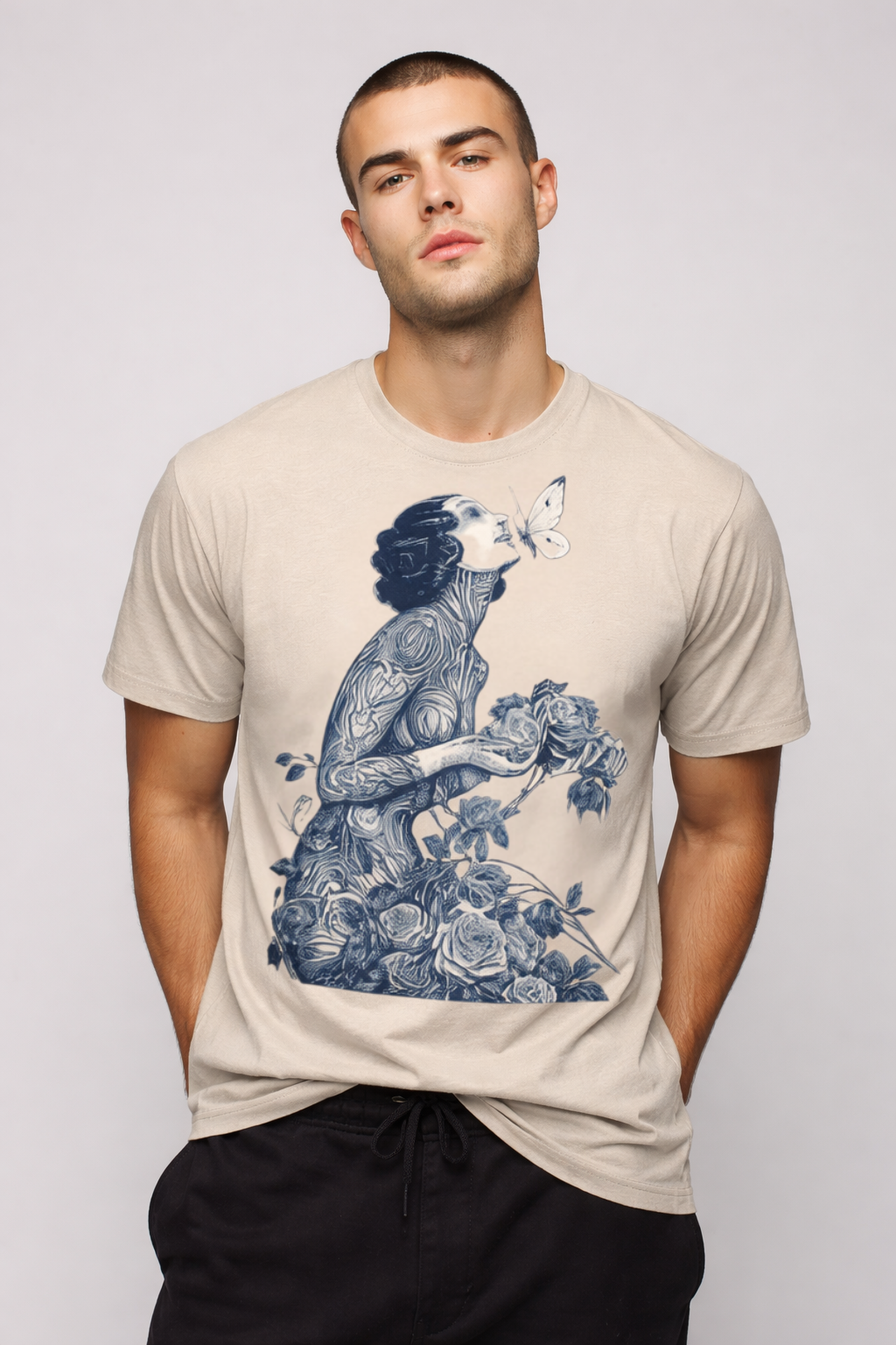 Man wearing a beige t-shirt with a blue graphic design on a plain background