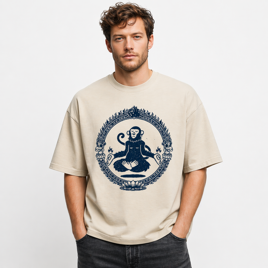 Man wearing a beige t-shirt with a blue graphic design on a plain background