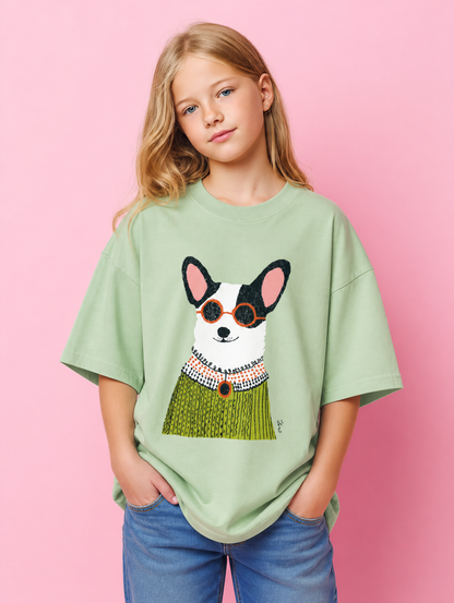 Young girl wearing a light green t-shirt with a dog graphic on a pink background