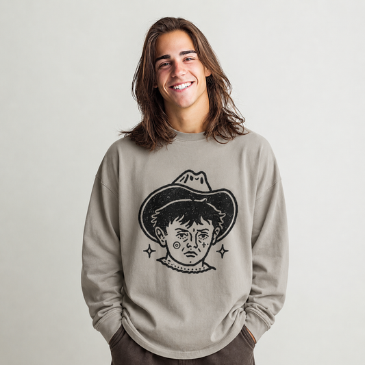 Person wearing a beige long-sleeve shirt with black graphic of a tattooed cowboy