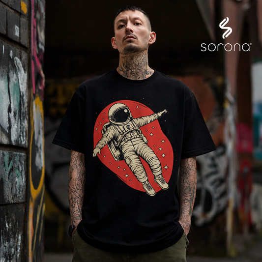 Person wearing a black t-shirt with an astronaut graphic, standing in an urban setting.