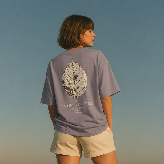 Person wearing a purple Found In Time graphic t-shirt featuring vintage-inspired artwork celebrating nostalgia, adventure, and timeless style.