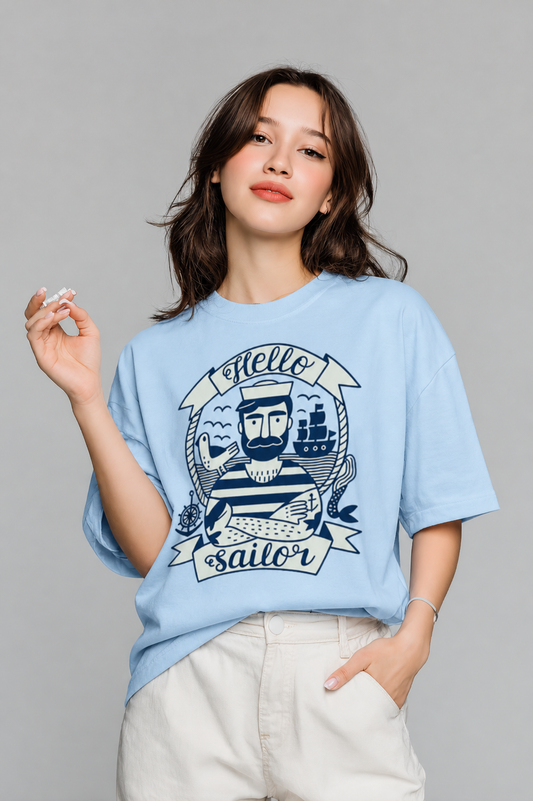 Woman wearing a light blue t-shirt with a 'Hello Sailor' graphic design on a gray background
