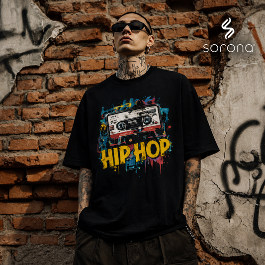 Person wearing a black t-shirt with a colorful 'HIP HOP' design against a graffiti-covered brick wall.