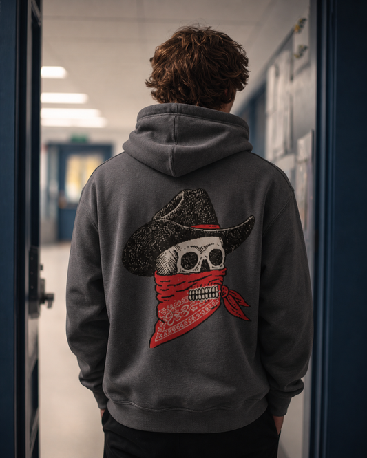 Person wearing a hoodie with a skull design in a hallway