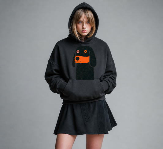 Person wearing a black hoodie with a dog graphic on a gray background
