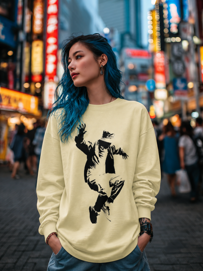 Person wearing a light yellow sweatshirt with a graphic design in a city street at night.