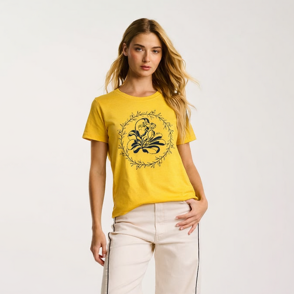 Woman wearing a yellow t-shirt with a design and beige pants on a white background