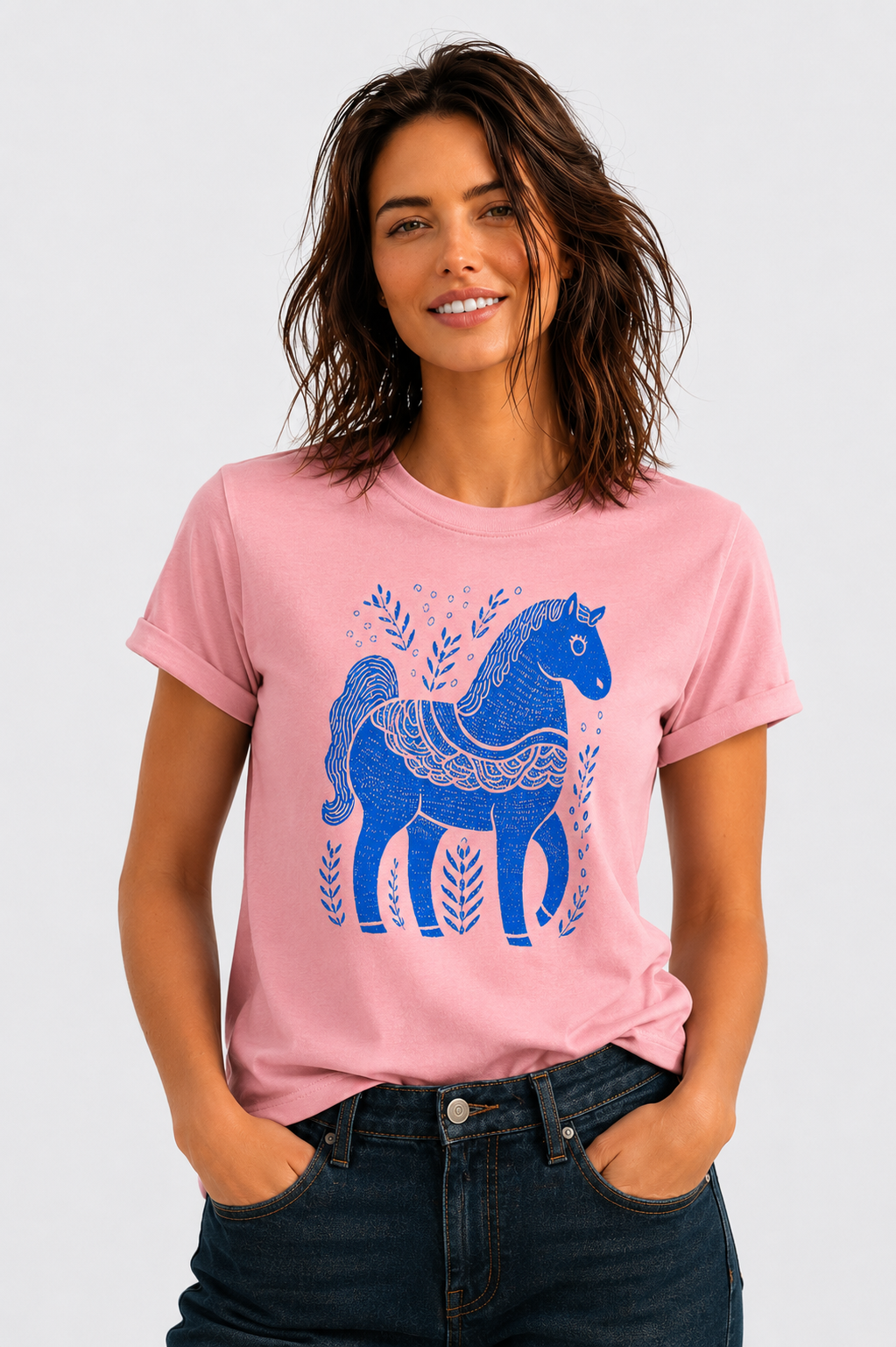 Woman wearing a pink Blue Folk Horse graphic t-shirt featuring folk art-inspired horse artwork celebrating creativity, tradition, and nature.