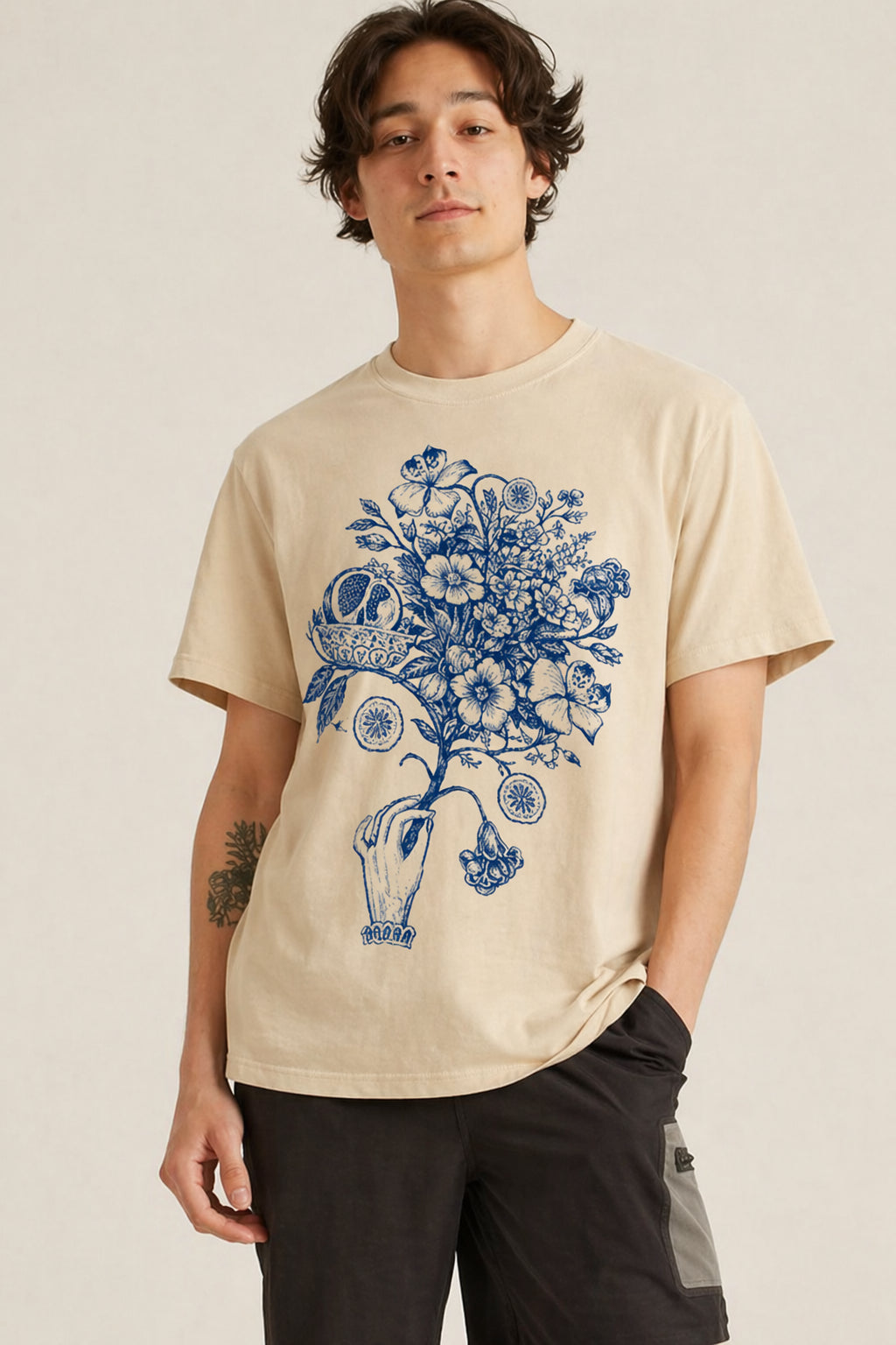 Man wearing a beige Botanical Hand Illustration graphic t-shirt featuring floral hand artwork inspired by botanical illustration and creative design