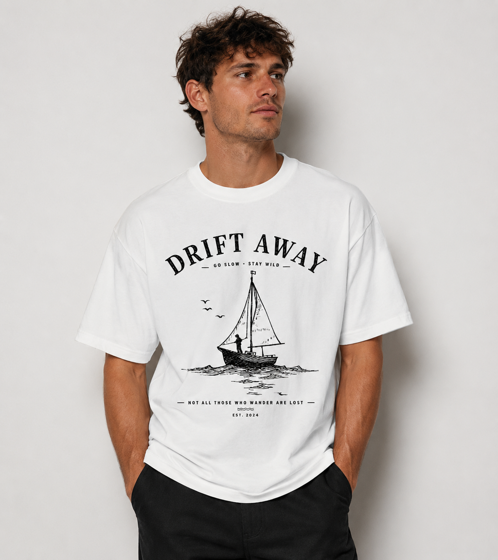 Man wearing a white Coastal graphic t-shirt featuring laid-back artwork inspired by ocean breezes, travel, and relaxation.