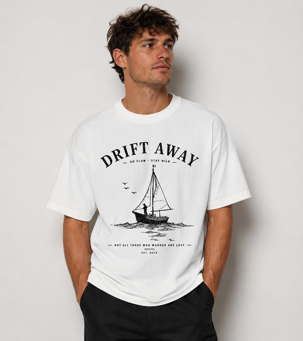 Man wearing a white Coastal graphic t-shirt featuring laid-back artwork inspired by ocean breezes, travel, and relaxation.