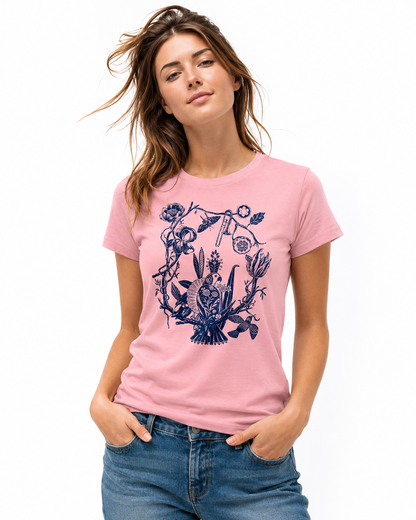 Woman wearing a pink women’s slim vintage t-shirt featuring a detailed blue floral bird illustration on the front against a clean studio background.